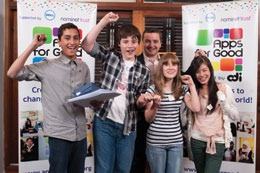 A group of excited young people and an adult celebrate their achievement in front of 'Apps for Good' banners.