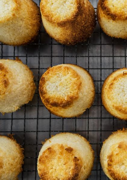 Overhead view of golden-brown macaroons on a metal cooling rack.