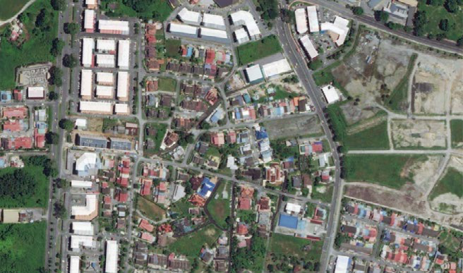 Aerial satellite view of an urban residential area with roads, buildings, and green spaces.