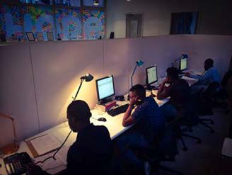 Employees working at computers in an office setting, illustrating a typical work environment.