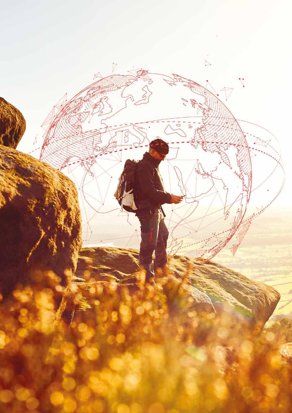 A person using a smartphone on a mountain, with a transparent red wireframe globe representing global connectivity overlaid.