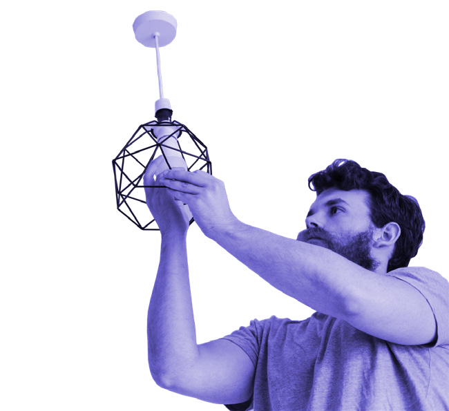 A man installing a light bulb into a modern geometric pendant lamp fixture.