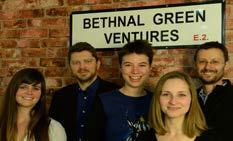 Five people, smiling, stand in front of a brick wall and a street sign that reads "BETHNAL GREEN VENTURES E.2."
