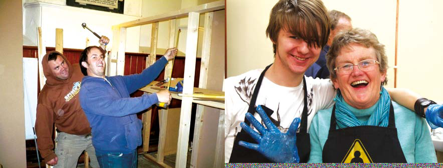 Two men building a wooden frame structure, and a young man with blue gloves laughing with an older woman.