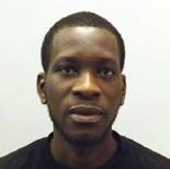 Color portrait of a man with dark skin and short hair, looking forward.