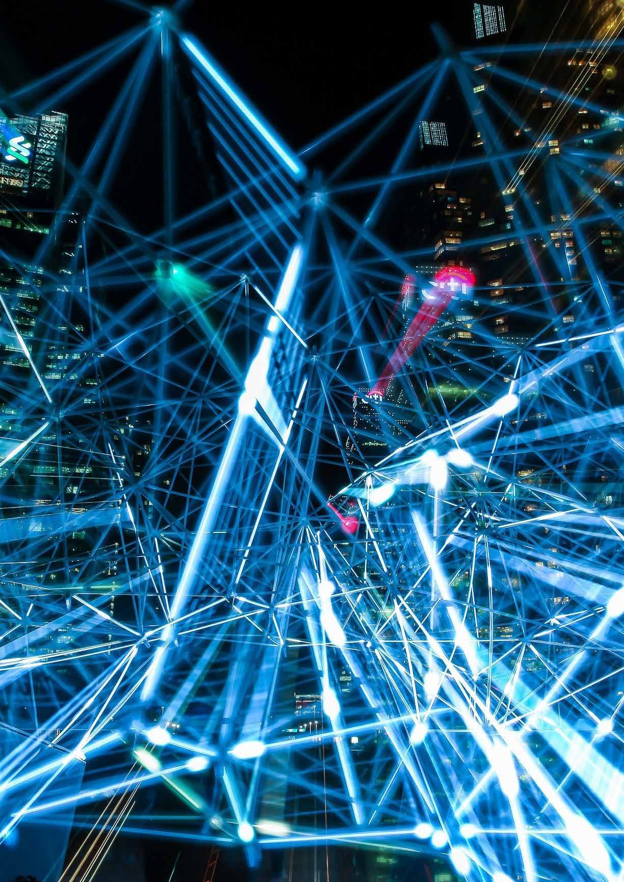 Abstract representation of a glowing blue network overlaying a dark city skyline at night, symbolizing data connection or digital infrastructure.