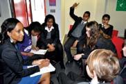 A group of diverse students in a classroom setting, engaged in an interactive discussion.