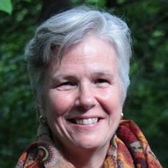 Headshot of a woman with short grey hair, wearing a patterned scarf, smiling.
