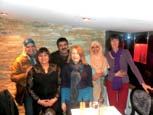 A diverse group of adults smiling and posing for a group photo indoors.