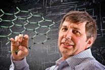 Scientist holding a molecular model with scientific equations on a chalkboard in the background.