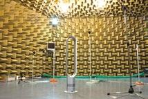 Anechoic chamber with foam walls, containing a Dyson fan and microphones set up for acoustic testing.