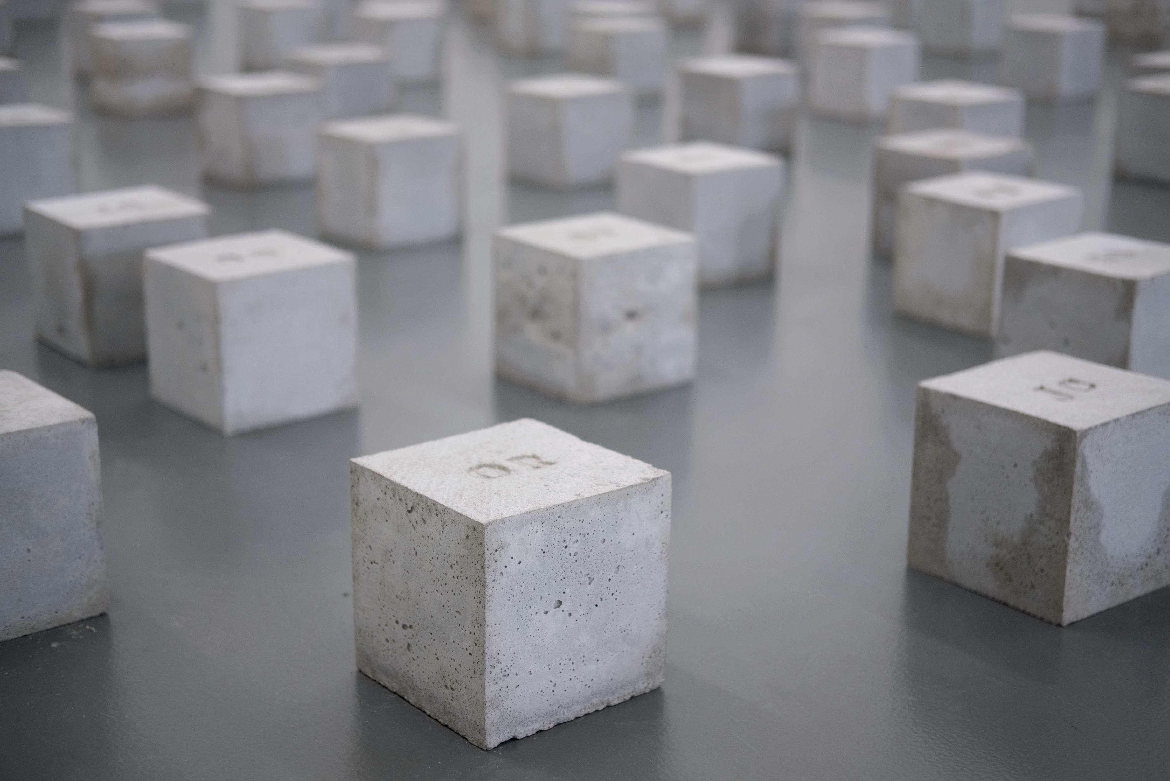 Grid of concrete cubes, many with numbers, possibly representing data points or a conceptual model.