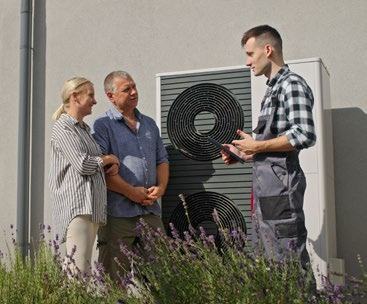 Technician explaining an outdoor HVAC unit to a couple during a consultation.