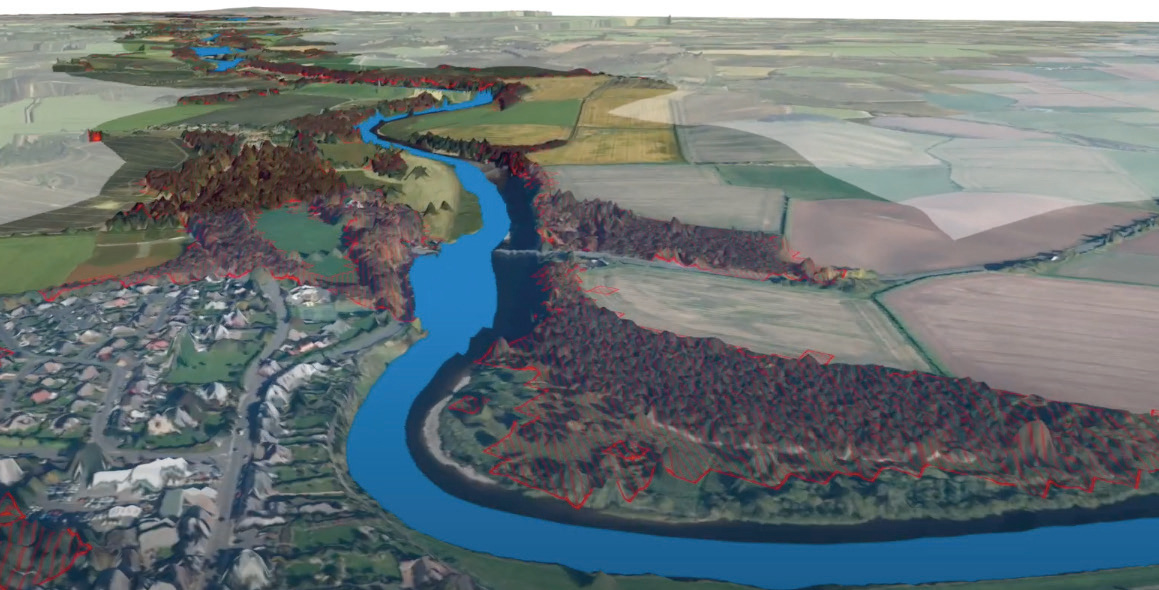 3D topographical map showing a river, surrounding landscape with red-outlined forest areas, and a town.