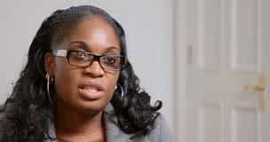 Headshot of a Black woman with braided hair and glasses speaking.