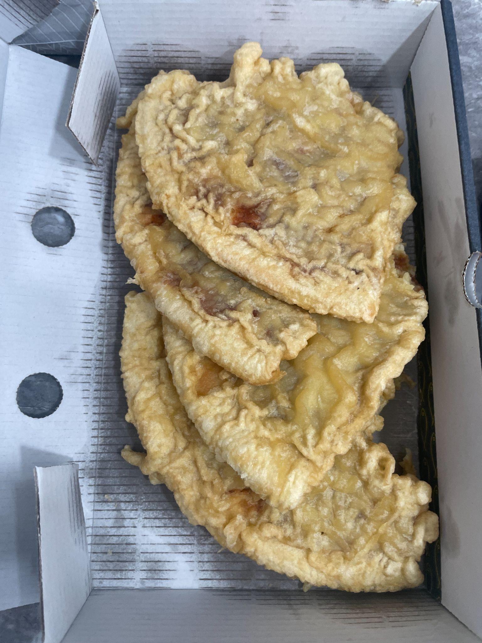 Fried battered food items in an open takeout box.
