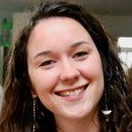 Headshot of a smiling white woman with dark hair.