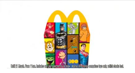 McDonald's Happy Meal box featuring characters like Batman, Superman, Scooby-Doo, and Tom & Jerry, promoting a pre-selected toy or book offer.