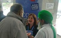 A woman from British Lung Foundation interacting with two men at an event.