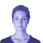 Headshot of a woman with short curly dark hair looking forward.