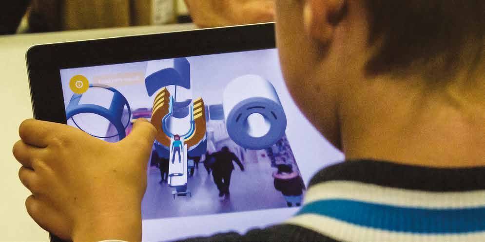 Child interacting with a tablet displaying augmented reality content, with virtual structures and people layered over a real-world scene.