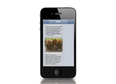 An iPhone displaying a WWF text message conversation with donation requests and an image of two tiger cubs.