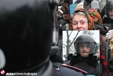 Photo from a protest or crowd, showing a police officer's helmet and reflections of a woman and another officer.
