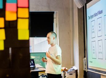 Man presenting "The Higher Island Values" visual framework on a whiteboard to an audience.