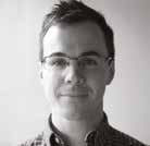 Headshot of a man with short hair and glasses, wearing a collared shirt, looking forward.