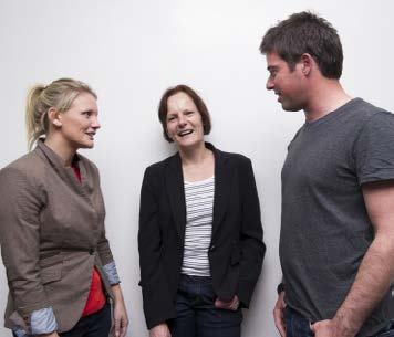 Three people, two women and one man, engaged in conversation against a white background.