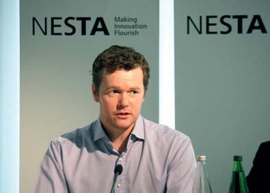 Close-up of a man speaking at a presentation or panel, with the "NESTA Making Innovation Flourish" logo visible in the background.