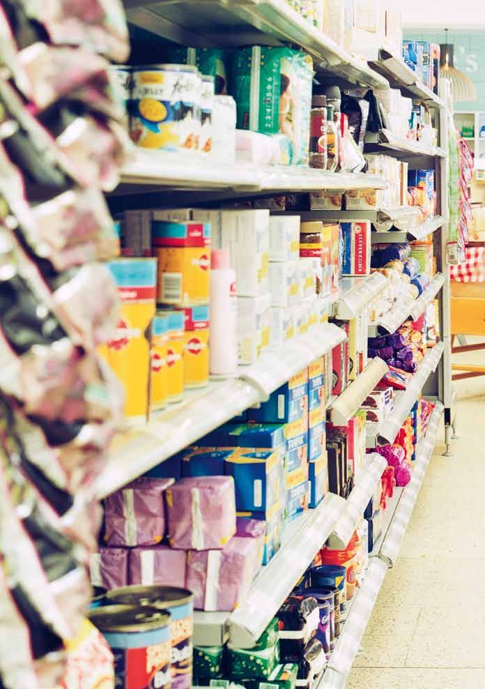A long grocery store aisle stacked with various packaged food items on white shelves.