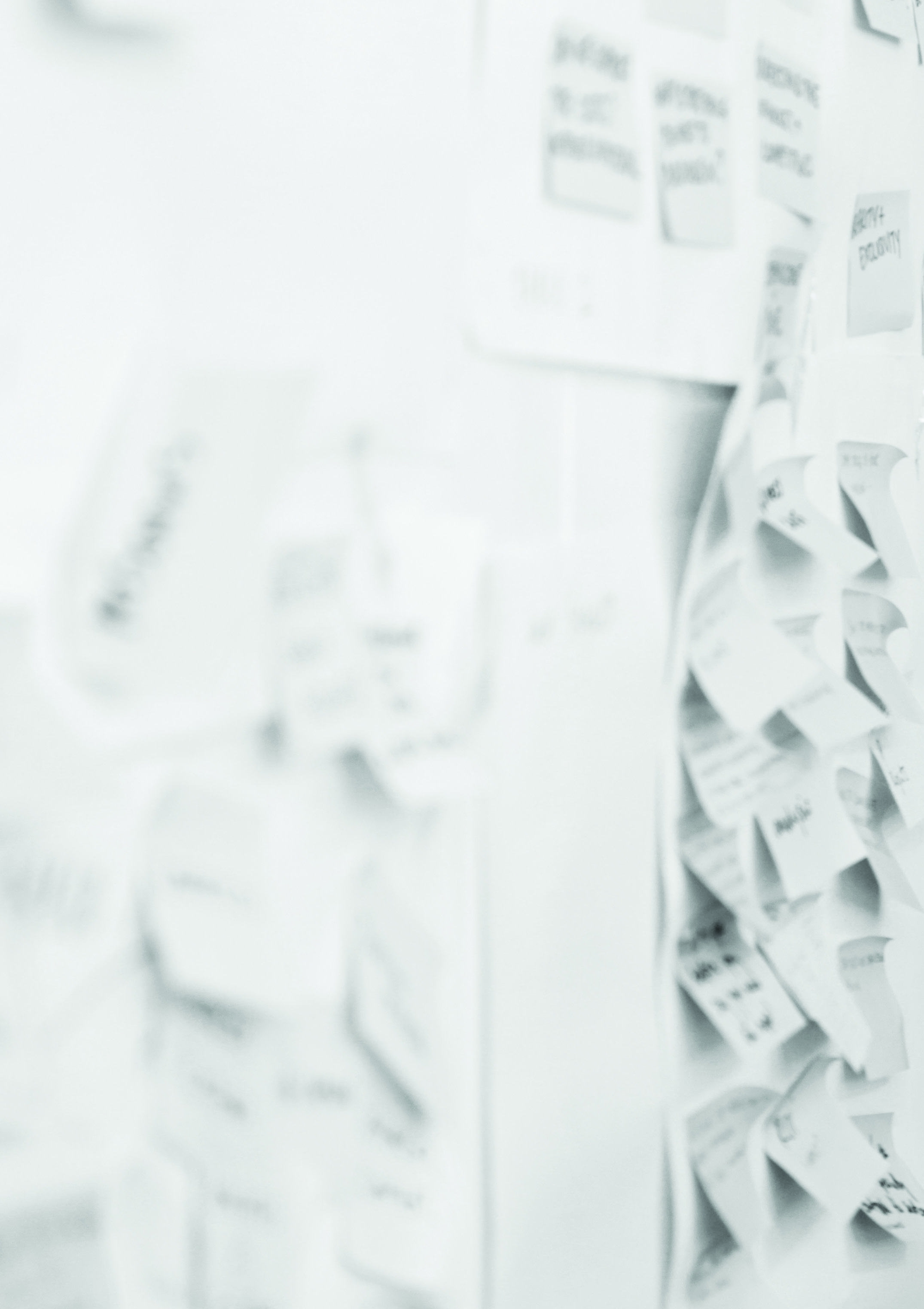 Blurred image of a wall covered in sticky notes, suggesting a brainstorming or ideation process.