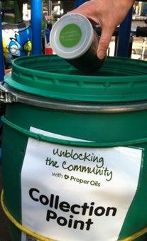 A hand deposits a container into a green collection barrel labeled "Collection Point" for "Proper Oils" and "Unblocking the Community."