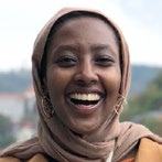 Headshot of a smiling woman wearing a hijab.