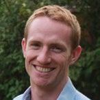 Headshot of a smiling man with red hair.