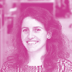 Portrait of a woman with long curly brown hair, smiling.