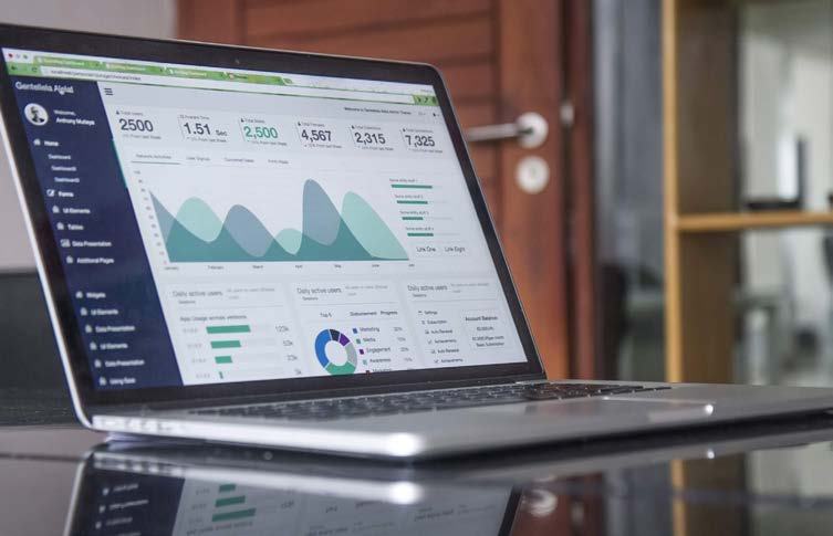Laptop screen displaying a data dashboard with various charts, graphs, and key performance indicators.