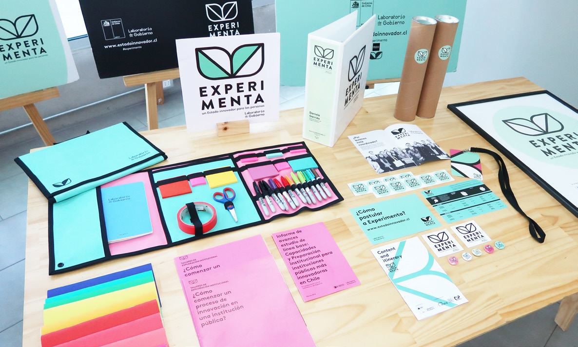 A display table featuring a range of branded "EXPERIMENTA" merchandise and informational materials, including folders, booklets, and promotional items.