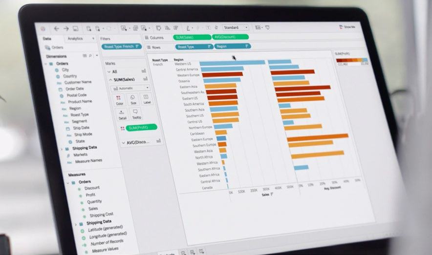 Laptop screen displaying a data visualization tool with a horizontal bar chart showing sales and discount metrics by region and roast type.