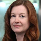 Professional headshot of a woman with long red hair, looking slightly off-camera.