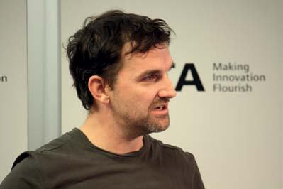 Man with dark hair and beard speaking at a Nesta event.