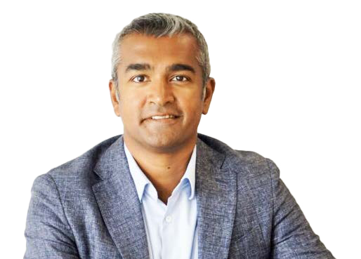 Headshot of a smiling man with short graying hair, wearing a light blue collared shirt and a grey blazer.