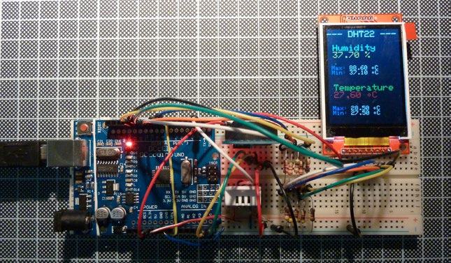 Electronic circuit board (Arduino) connected to an LCD screen displaying humidity and temperature readings from a DHT22 sensor.