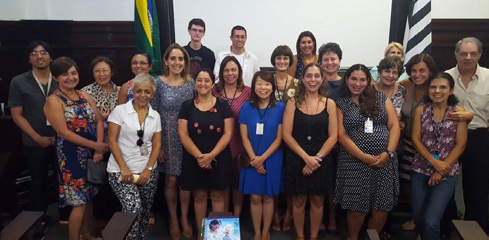 A large group of diverse adults posing for a group photo in a room, likely after a meeting or event.