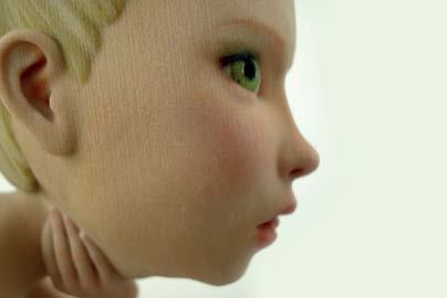 Close-up side profile of a realistic-looking doll's head with blonde hair and green eyes, demonstrating detailed craftsmanship.