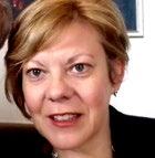 Headshot of a smiling woman with short blonde hair.