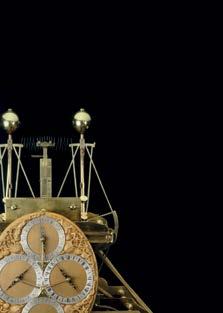 Close-up of an intricate antique scientific instrument with multiple clock dials and brass components on a black background.