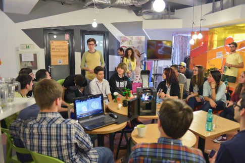 A group of young people attending a presentation or workshop in a modern, informal office space.