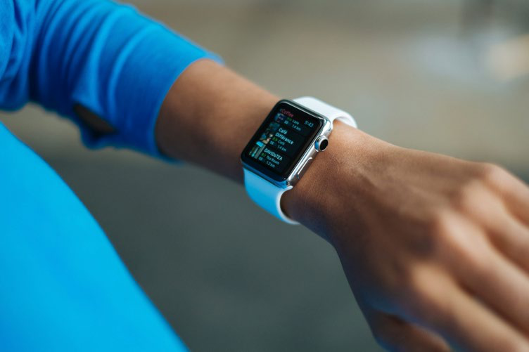 Close-up of a person's wrist wearing an Apple Watch displaying fitness or activity tracking data on its screen.